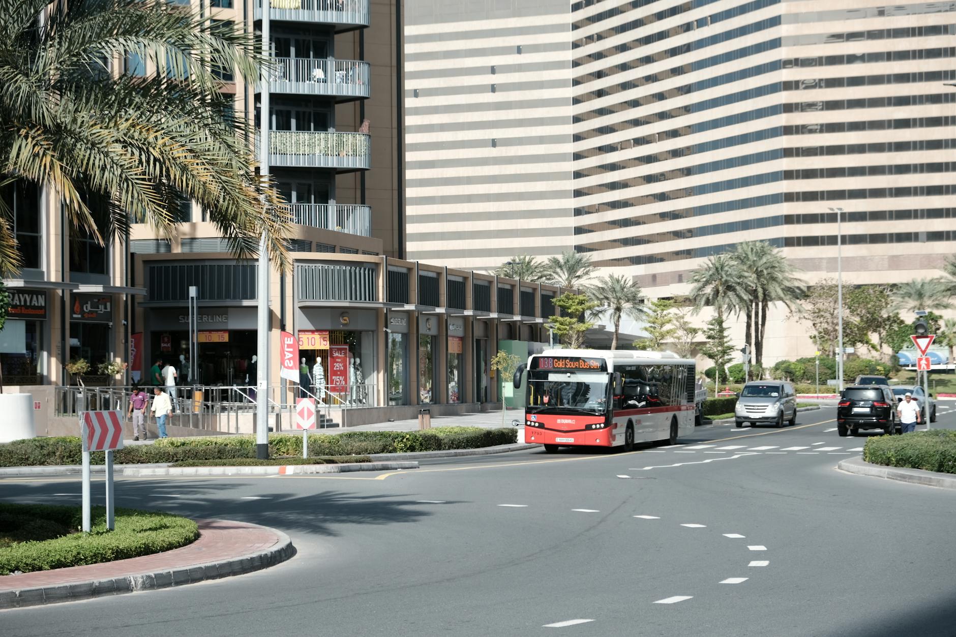 Dubai street scene with RTA bus, shops, and palm trees near Gold Souk